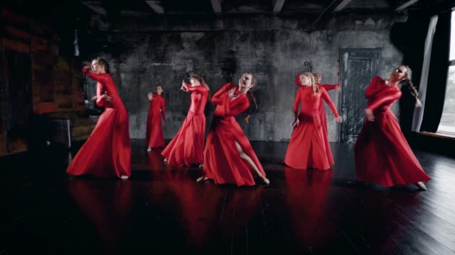 sieben-charmante-Tänzer-Frauen-tanzen-in-Halle-Proben,-rote-Kleider-tragen,-am-Boden-liegend