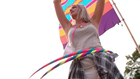 Girl-hula-hooping-with-two-hoops-at-a-festival,-slow-motion