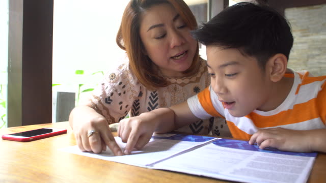 Glückliche-asiatischen-Familie-Eltern-und-Jungen-lesen-zusammen