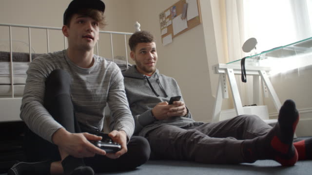 Estudiantes-masculinos-usar-teléfono-y-jugando-Video-juego-tiro-de-R3D