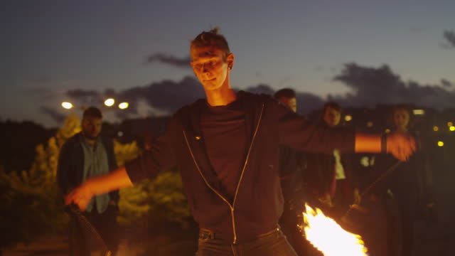 Männliche-Künstler-Feuershow-im-Freien-am-Abendzeit-durchführen.