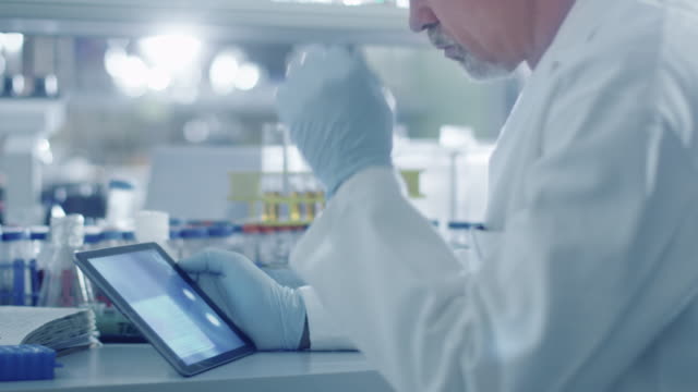 Leitende-männliche-Wissenschaftlerin-nutzt-einen-Tablet-Computer-in-einem-Labor.
