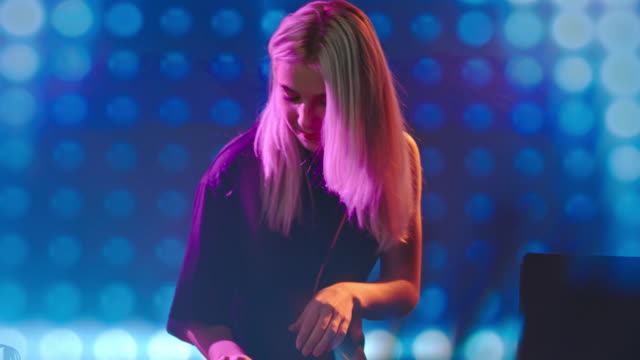 Woman-DJ-Playing-Decks-in-Nightclub