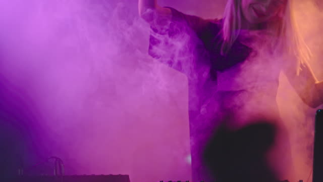 Female-DJ-Playing-Set-in-Smoky-Club