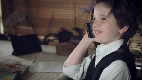 Tiro-alta-tecnología-de-4-K-de-un-niño-haciendo-la-tarea-y-hablar-con-mamá-en-Smartphone