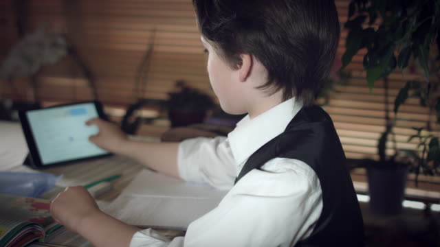 4K-Hi-Tech-Shot-of-a-Child-Doing-Homework-with-Help-from-Tablet