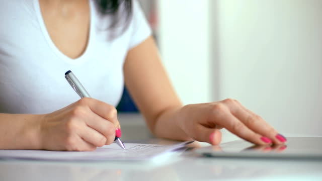 Weibliche-Hand-mit-Stift-schreiben-in-notebook