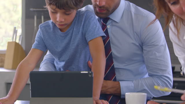 Parents-Helping-Son-With-Homework-Before-Going-To-Work