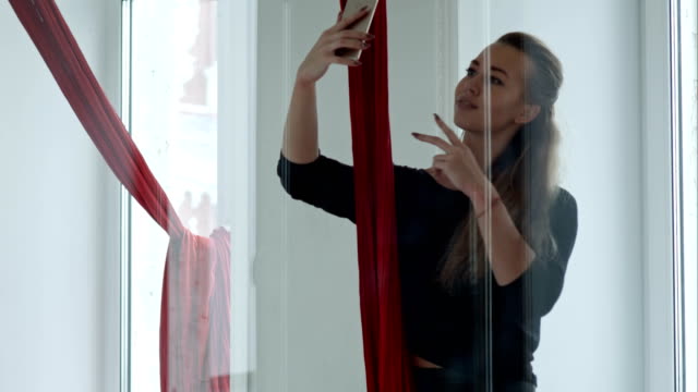 Hermosa-bailarina-tomando-selfie-con-smartphone-seda-aérea-después-de-entrenamiento
