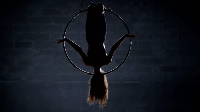 Flexibles-Mädchen-hängt-kopfüber-in-den-aerial-hoop