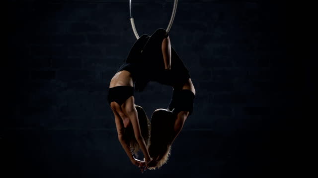 Two-beautiful-gymnasts-performs-trick-at-the-aerial-hoop