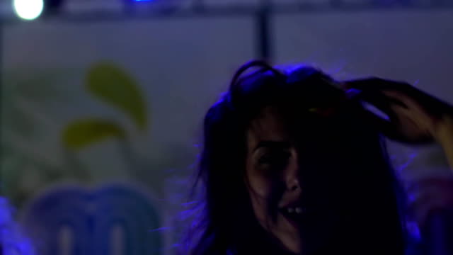 close-up-happy-girl-dance-at-night-club-with-glass-cocktail,-beautiful-woman-with-beverage-on-party-in-blue-lights