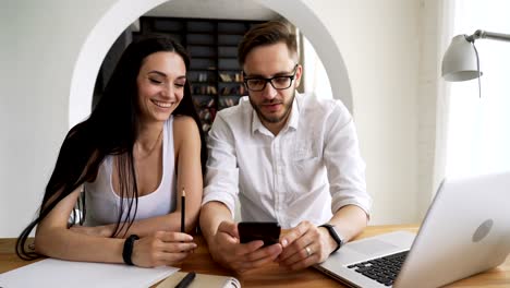 Partners-take-selfies-at-cellphone-in-workspace