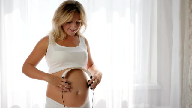 music-pregnancy,-future-baby-listens-to-music-in-big-tummy