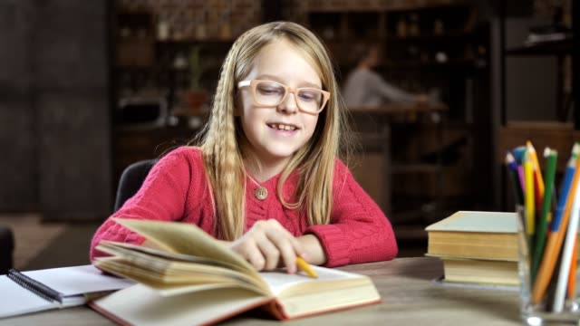 Fröhliches-Mädchen-schreiben-ihre-Hausaufgaben-für-die-Schule