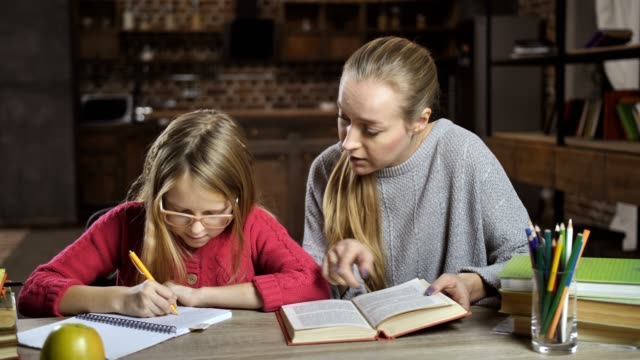 Mutter-ihre-Tochter-bei-den-Hausaufgaben-zu-Hause-helfen