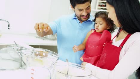 Ethnic-pre-school-girl-parents-baking-home-kitchen