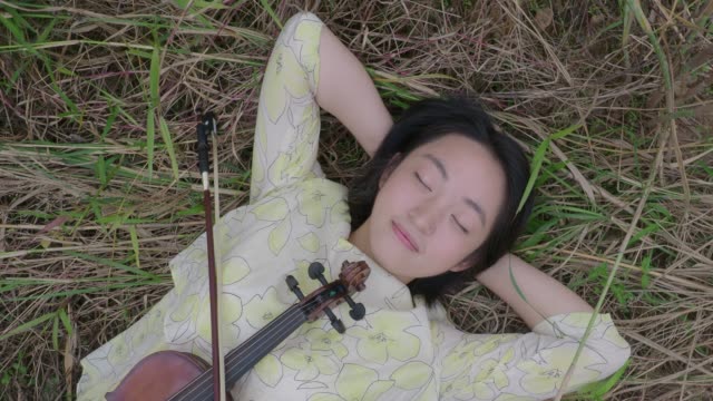 Mujer-asiática-adolescente-tocando-un-violín