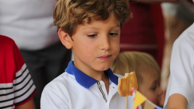 Young-boy-holding-cookie.-Candid-4K-clip-of-child-at-a-children-party-eating-sweets