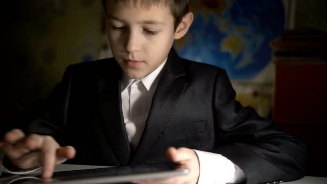 Junge,-die-Hausaufgaben-zu-Hause-mittels-tablet