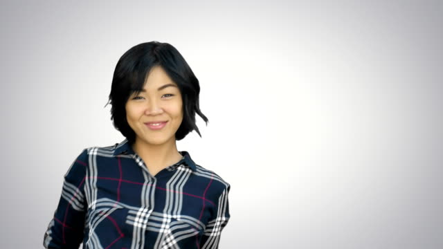 Junge-asiatische-Frau-Lächeln-und-tanzen-auf-weißem-Hintergrund