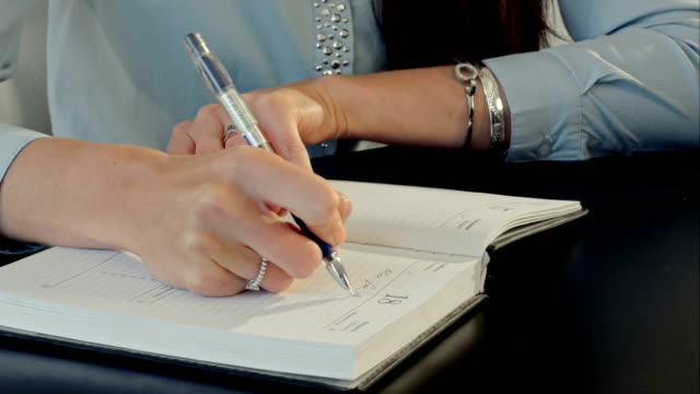 Weibliche-hand-Schreiben-in-notebook