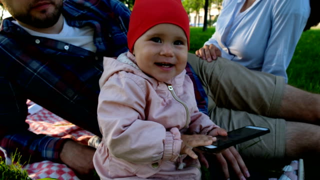 Niña-bebé-sosteniendo-smartphone-en-las-manos-y-riendo-cerca