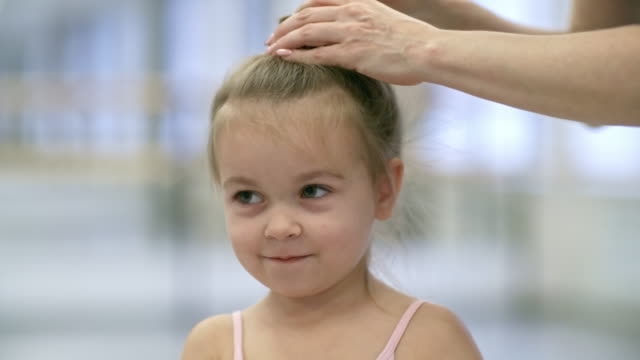 Ayudar-a-hija-prepararse-para-clase-de-Ballet