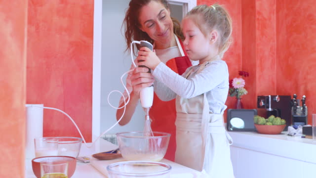 kleine-Mädchen-und-Mutter-Schlagsahne-Eier-mit-elektrischen-mixer