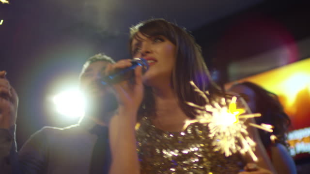 Mujer-cantando-Karaoke-con-fuegos-artificiales-luces-de-Bengala