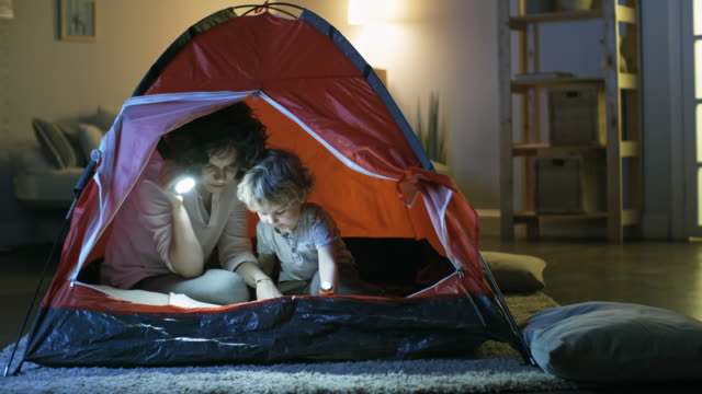 Mother-and-Son-Reading-Book-in-Tent