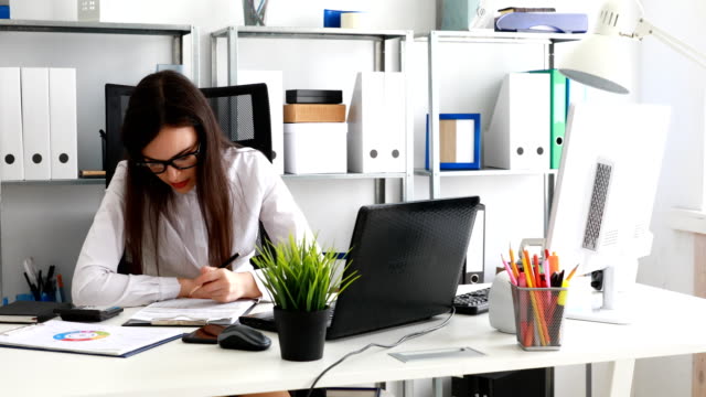 empresaria-llenar-documentos-y-trabajando-en-equipo-portátil-en-la-oficina-moderna