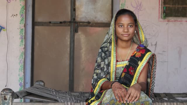 Mediados-tiro-de-niña-adolescente-indio-sentado-en-casa-con-el-vestido-sari-tradicional-namaste-respeto-cubierta-cabeza-mirando-a-cámara-unir-henna-manos-tatuadas-para-el-saludo-sonriente-contenido-ajuste-estático