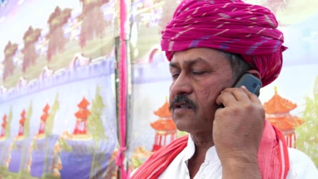 Handheld-Nahaufnahme-eines-Mannes-reden-Ernst-auf-seinem-Handy-in-Rajasthan