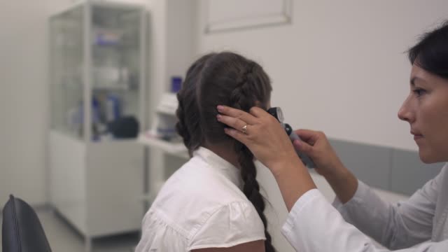 La-enfermera-examina-el-oído-de-una-muchacha