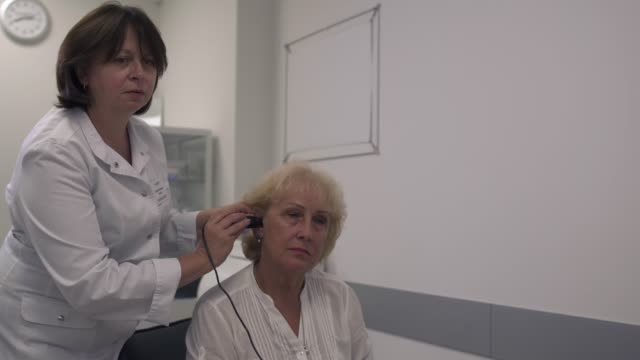 Arzt-testet-das-Ohr-einer-Erwachsenen-Frau