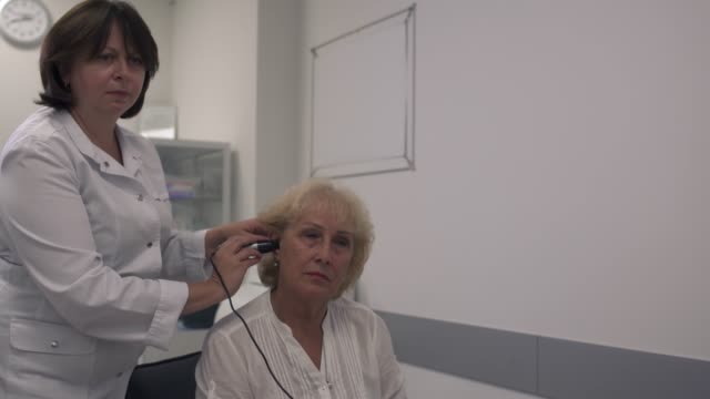 Profesional-médico-pruebas-del-oído-de-una-mujer-adulta