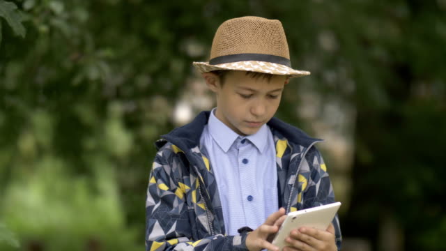 Landwirt-Junge-mit-Hut-einen-Tablet-im-Garten-verwendet,-überprüft-die-Ernte