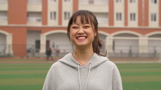 Portrait-of-young-asian-girl-smile-at-camera-in-campus