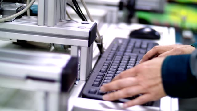 Eine-Nahaufnahme,-Hände-Arbeit-auf-der-Tastatur.-ein-Arbeitnehmer-in-einem-Betrieb,-einer-Produktion,-in-der-Werkstatt,-regelt-den-Betrieb-eines-mechanisierten-Prozesses-durch-einen-computer