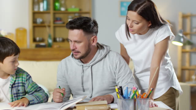 Mutter,-Vater-und-Sohn-gemeinsam-Hausaufgaben