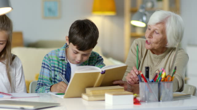 Niños-haciendo-la-tarea-con-ayuda-de-la-abuela