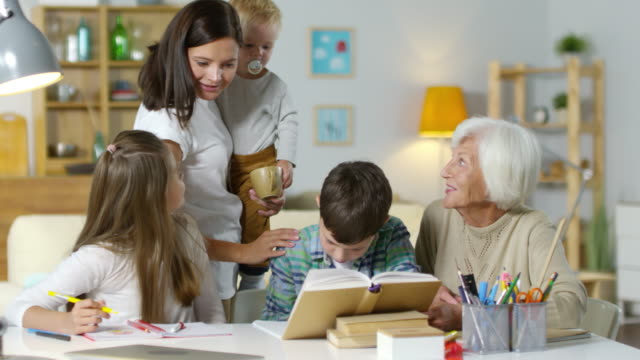 Niños-estudiando-en-casa-con-la-abuela-mientras-la-madre-Coddling-un-bebé