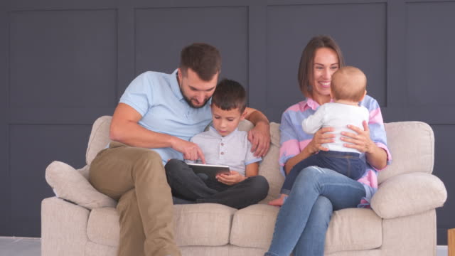 Glückliche-Familie-mit-digitalen-Tablet-zu-Hause