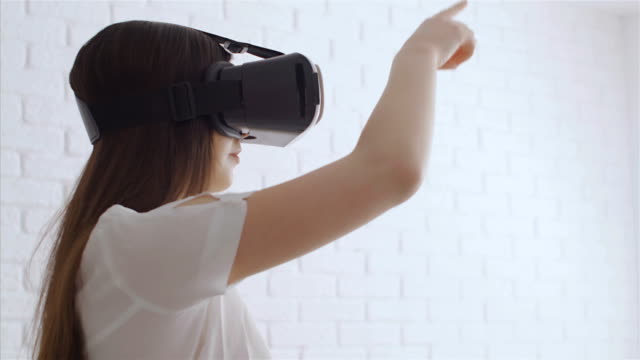 Junge-Frau-zu-berühren,-etwas-mit-modernen-virtual-Reality-Brille,-4k