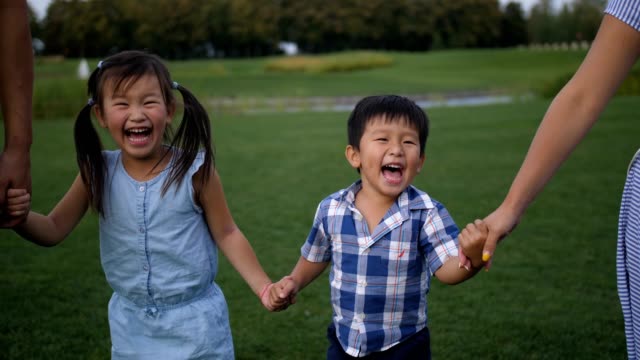 Porträt-des-Lachens-asiatischen-Geschwister-zu-Fuß-im-park