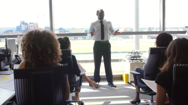 Afroamerikanische-manager-spricht-zu-Kollegen-im-Büro