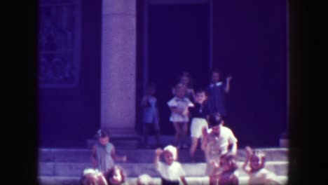 1949:-Kids-leaving-school-walk-down-slick-stone-staircase-with-no-handrails,-teachers-follow.