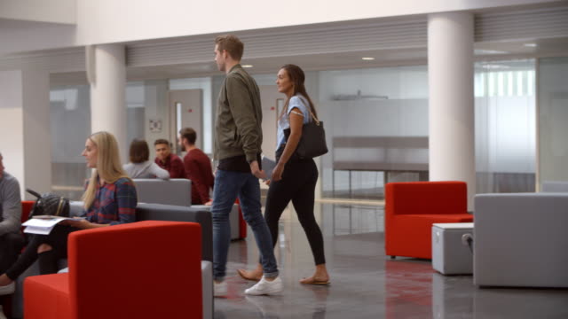 Students-walking-through-meeting-area-in-a-university-lobby