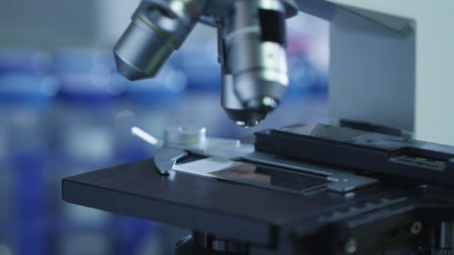 Close-up-footage-of-a-scientist-setting-up-a-microscope-in-a-laboratory.